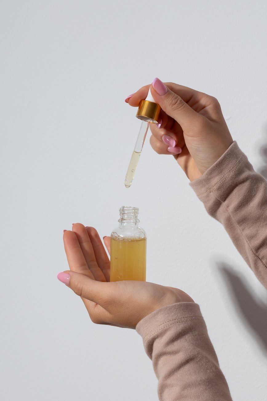 Person's Hands Holding a Bottle of Serum